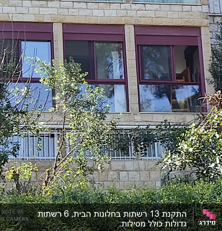 חלונות אלומיניום עם מסגרות אדומות בבניין